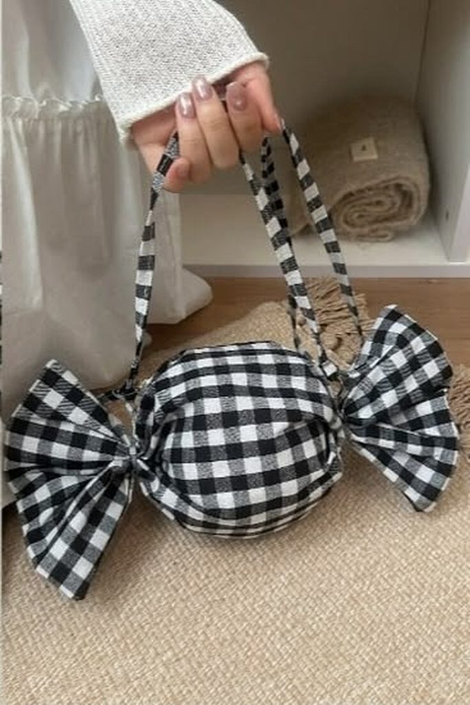 Gingham bow candy bag sewing pattern, black and white crossbody purse held by hand